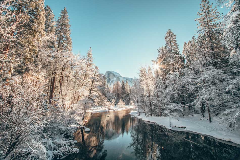 River surrounded by snow covered trees during the morning light in Yosemite National Park Unsplash